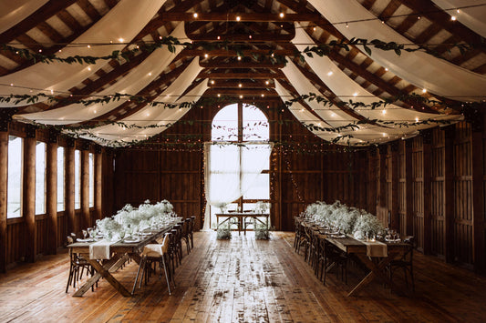 rustic chic barn wedding decor with greenery garlands, string lights, fairy lights, baby's breath and fabric draping panels